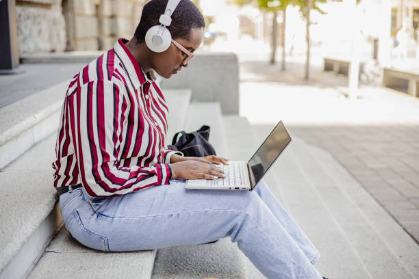 istock Young woman using laptop in front of the University 1340120536
