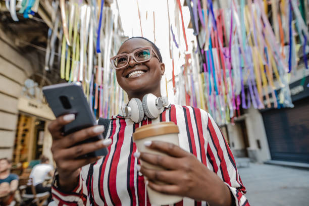 istock African-American woman walking and using mobile phone 1340120951