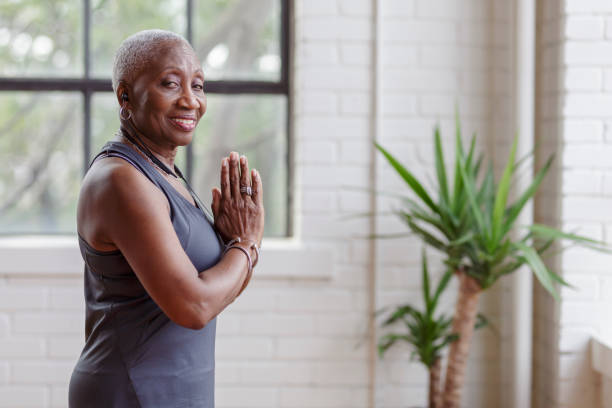istock Active senior woman doing yoga at home 1340124931