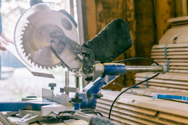 istock Professional miter saw standing on stack of boards with trim planks for house cladding, construction and repair concept 1340125974