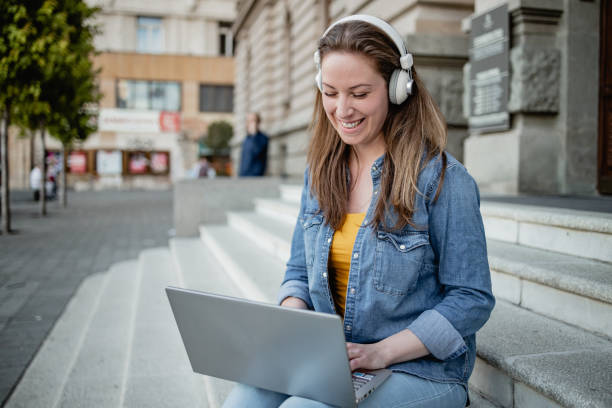 istock Young woman using laptop in front of the University 1340127675