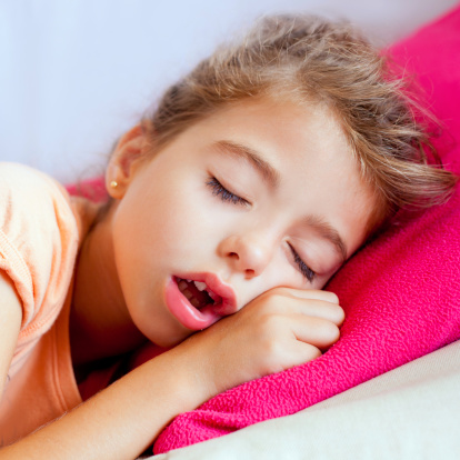 Deep sleeping children girl closeup portrait on pink pillow