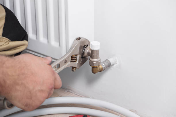 istock Plumber installing new steel hot water central heating radiator 1340132692