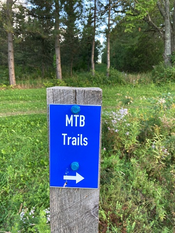 Blue mountain biking trail sign in nature.