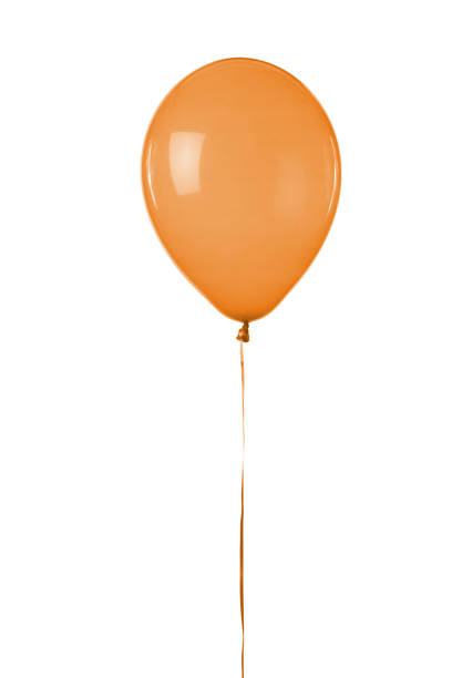 One orange balloon flying in the blue sky
