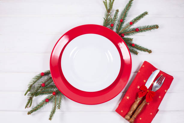 istock Christmas Table Setting with fir branch and red decorations on white background 1340142566