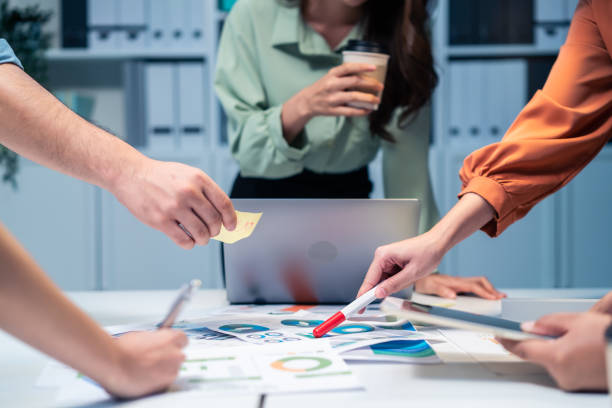 fermez les mains d’un groupe d’hommes et de femmes se réunissant au bureau. les employés réfléchissent et travaillent en équipe, planifient et discutent projet par point sur papier. entreprise de collègues ou de collègues modernes. - visage caché photos et images de collection