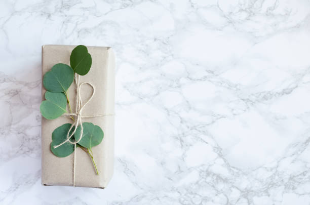 istock Gift box wrapped in brown paper decorated with eucalyptus branch 1340144313