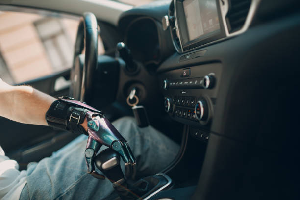 istock Young disabled man driver with artificial prosthetic hand driving vehicle car and switches gearbox. 1340144964