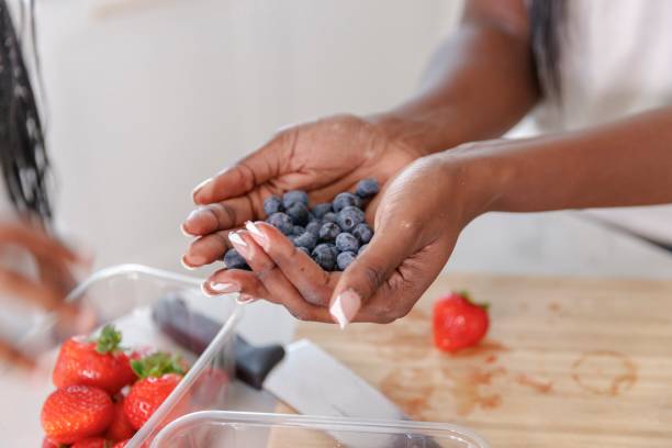 istock Black woman holding fresh blueberries 1340144988