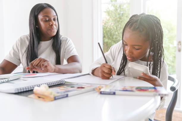 istock Mother helping elementary age daughter with homework at home 1340145006