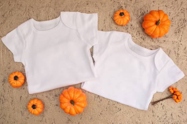 istock Two White baby bodysuits mockup on golden wooden 1340148056
