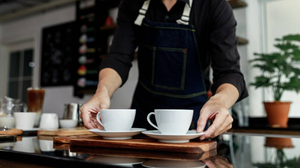 istock selective focus white coffee mug on hand coffee maker in coffee shop Thailand 1340148229