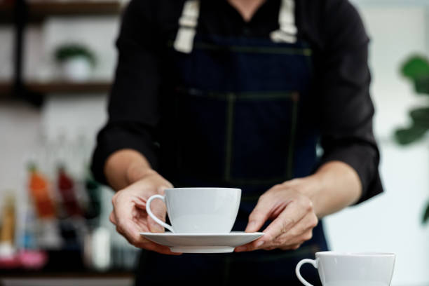 istock selective focus white coffee mug on hand coffee maker in coffee shop Thailand 1340148240