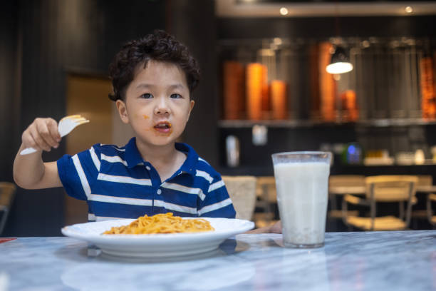 istock A little boy eating pasta in a restaurant 1340155115