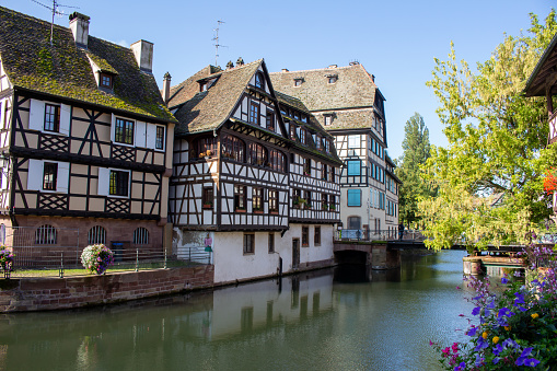 This image shows beautiful French and German inspired traditional half-timber framed homes along the idyllic Ill River in Strasbourg, France.