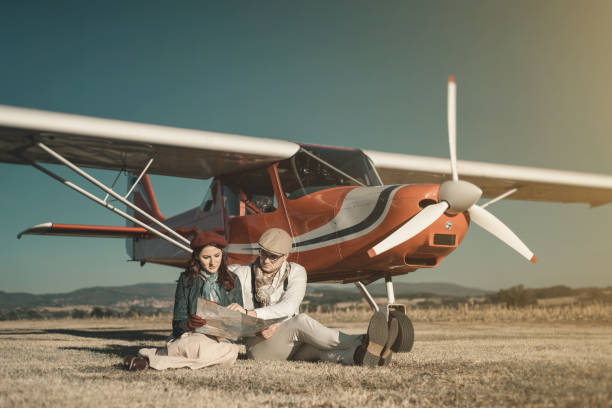 Young lovers looking at map near their private small plane, classy tourism concept Young lovers looking at map near their private small plane, classy tourism concept ultralight photos stock pictures, royalty-free photos & images
