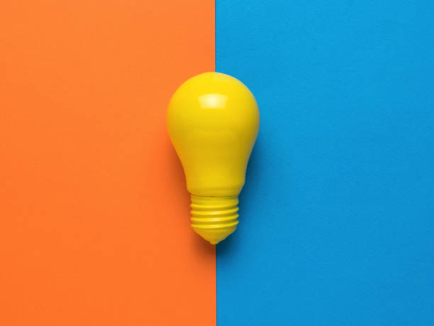 istock A bright yellow light bulb on an orange and blue background. Minimalism. Flat lay. 1340160364