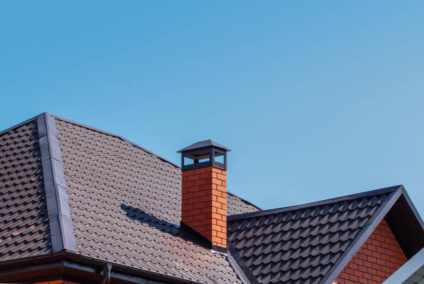Brick chimney pipe on metal roof of a private house against the sky The exterior of the roof of a country house against the sky. Brick chimney pipe on metal roof of a private house. Individual heating system. Rain gutter. red brick tile stock pictures, royalty-free photos & images