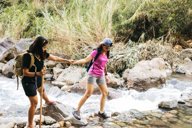 istock two young woman  hiking crossing a river 1340168394