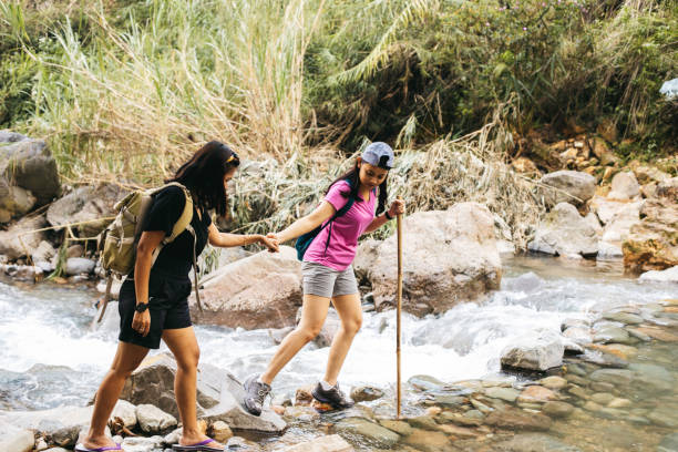 istock two young woman  hiking crossing a river 1340168424