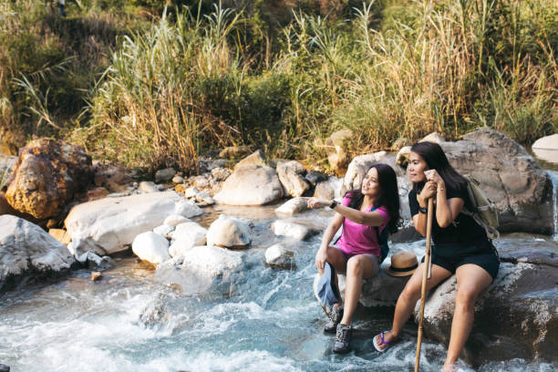 istock two young woman  hiking crossing a river 1340168637