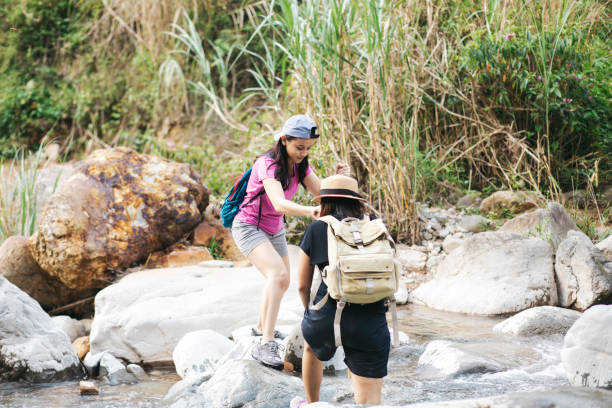 istock two young woman  hiking crossing a river 1340168765