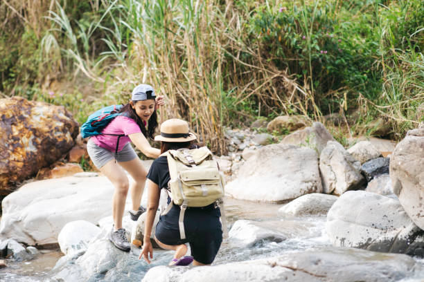 istock two young woman  hiking crossing a river 1340169358