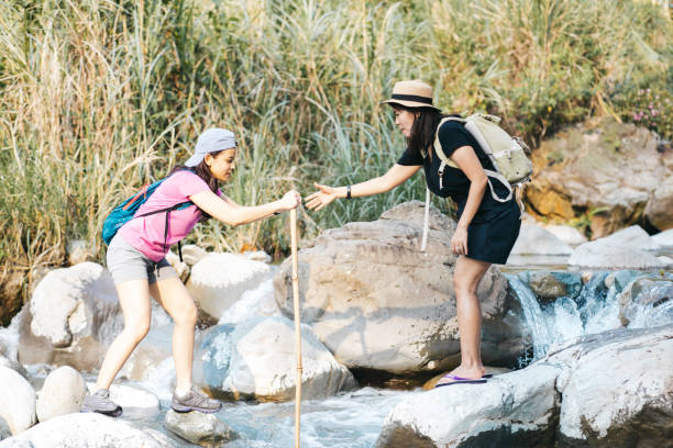 istock two young woman  hiking crossing a river 1340169711