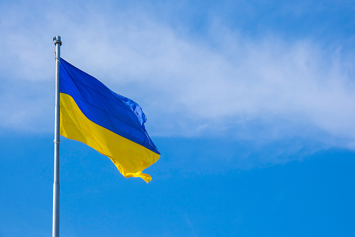 La bandera nacional ucraniana ondea en el viento contra el cielo azul. Símbolo nacional del pueblo ucraniano: la bandera azul y amarilla ondear en el viento photo