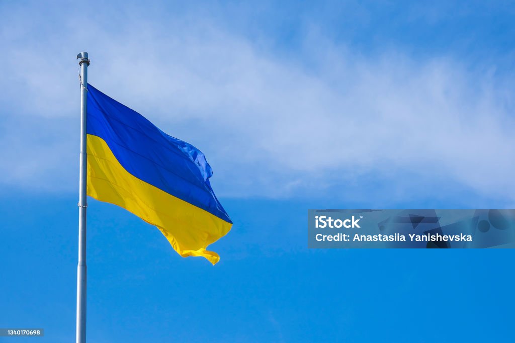Ukrainian national flag flutters in the wind against the blue sky. National symbol of ukrainian people - blue and yellow banner is fluttering in the wind Ukrainian national flag flutters in the wind against the blue sky. National symbol of ukrainian people - blue and yellow banner is fluttering in the wind. Independence day Copy space Ukrainian Flag Stock Photo