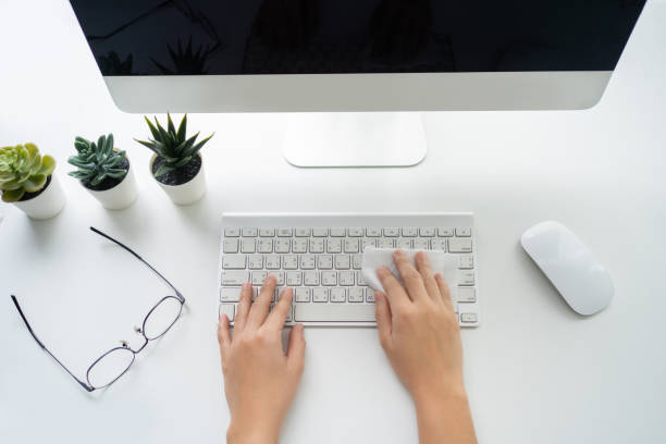 istock Top view of desktop with keyboard and computer. Human hands wipe the keyboard with an antiseptic cloth for disinfection. 1340178870