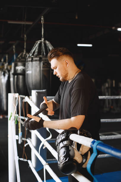 istock Man in a black t-shirtg boxing in a gym 1340186314