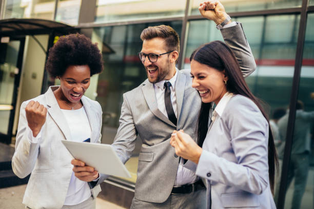 istock Business team celebrating a triumph, looking at digital tablet. 1340186545