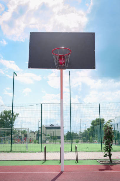istock Basketball backboard with a basket made of iron chains on a sunny day. Vertical view. Low angle view 1340186552