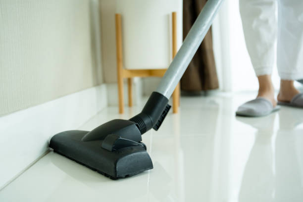 istock Asian housewife using vacuum machine cleaning her house. 1340187371