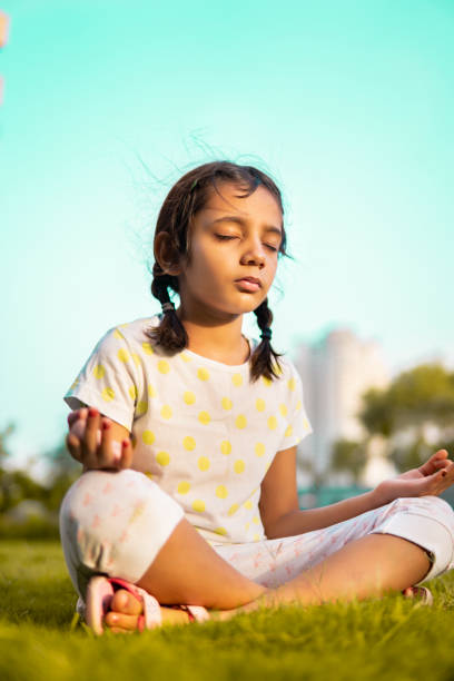 istock Indian little girl practicing yoga at park. 1340188807