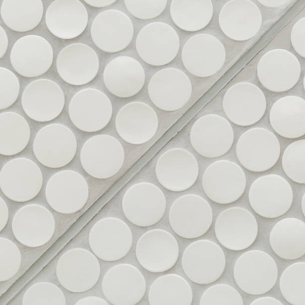 istock Closeup of white circles on a gray background divided by a line into half. background texture 1340193320
