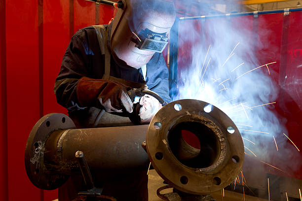 istock factory worker welding metal and sparks spreading 134019562