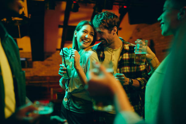 joven pareja feliz enamorada de divertirse en un pub por la noche. - coquetear fotografías e imágenes de stock