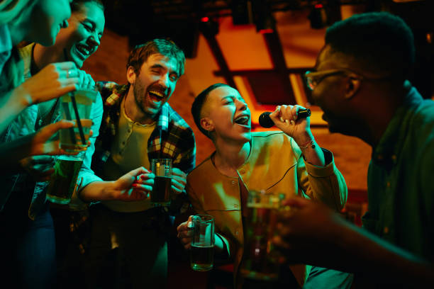 istock Cheerful friends having fun while singing karaoke during their night out in a pub. 1340197168