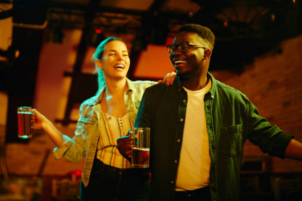 istock Young happy couple dancing and having fun in a bar at night. 1340197253