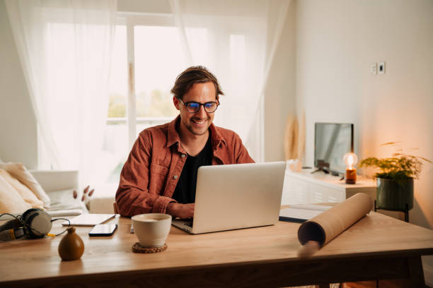 Caucasian male working from home typing on laptop finishing project