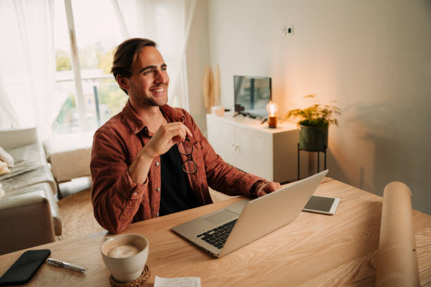 istock Caucasian male student working from home smiling while typing on laptop 1340200029