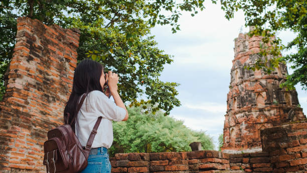 donna asiatica viaggiatrice che usa la fotocamera per scattare una foto mentre trascorre un viaggio di vacanza ad ayutthaya, in thailandia. - fotocamera compatta foto e immagini stock