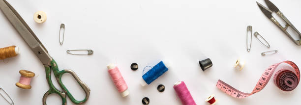 istock Flat lay composition with threads, scissors, buttons, needles, pins and other sewing accessories on white background. Long banner, top view, copy space, flat lay, mock up. Spase for text 1340201104
