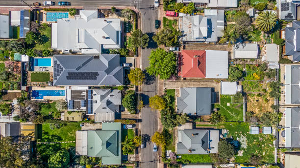 Aerial view of leafy eastern suburb houses either side of suburban street in Adelaide, South Australia Aerial view of leafy eastern suburban houses either side of suburban street in Adelaide, South Australia: directly above, rooftop solar,  front & backyard, play equipment, variety of roofing materials and colours; motor vehicles; garden; 16x9 format tree lined driveway stock pictures, royalty-free photos & images