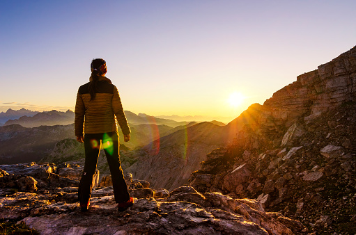 A woman enjoys beautiful sunrise in the mountains