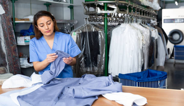 istock Focused woman dry-cleaning worker checking clean clothes 1340205406