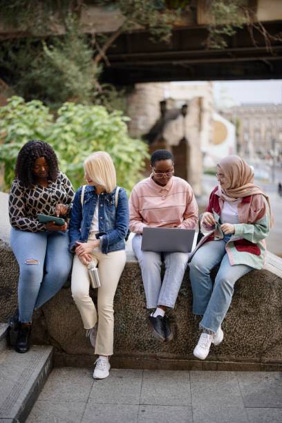 istock Multiethnic friends talk about lectures and use technology on the city streets 1340214207